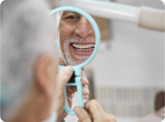 An aged man viewing his face in mirror