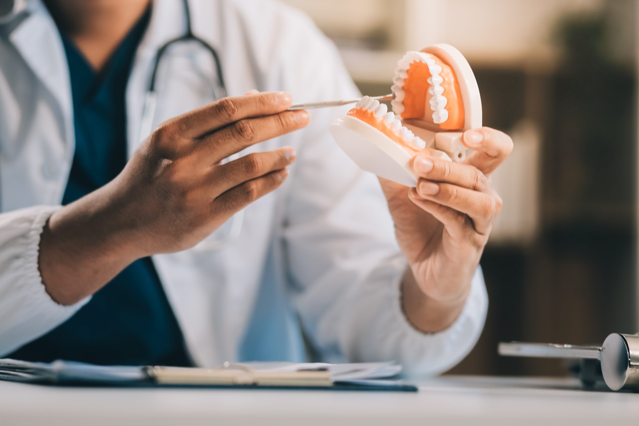 doctor explaining dentures to a patient using a model